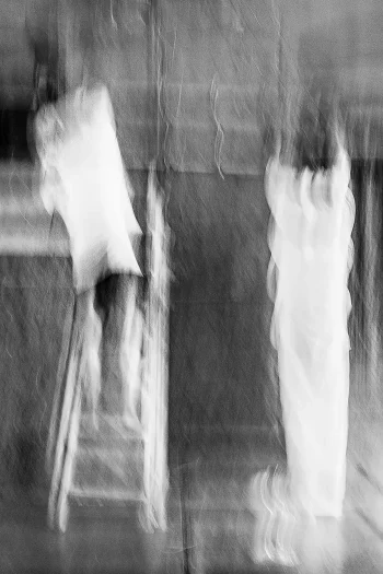 A boy on a ladder reaches upwards, a woman in white stands still beside him in a square at night in Kolkata – ICM Photography Kolkata: Veil of Light by Marion Rockstroh-Kruft